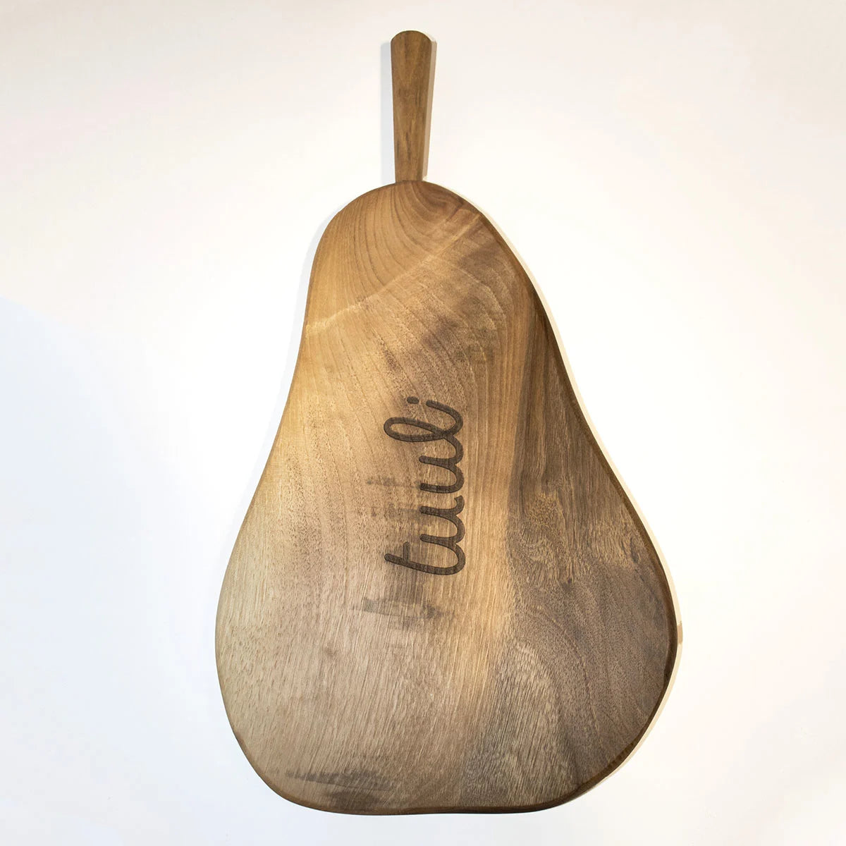 Artisanal walnut cutting board with juice groove feature demonstrated with freshly cut fruit