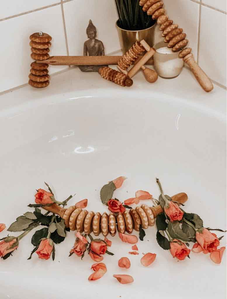 Lifestyle scene: massage rollers on bathroom shelf with towel and flowers